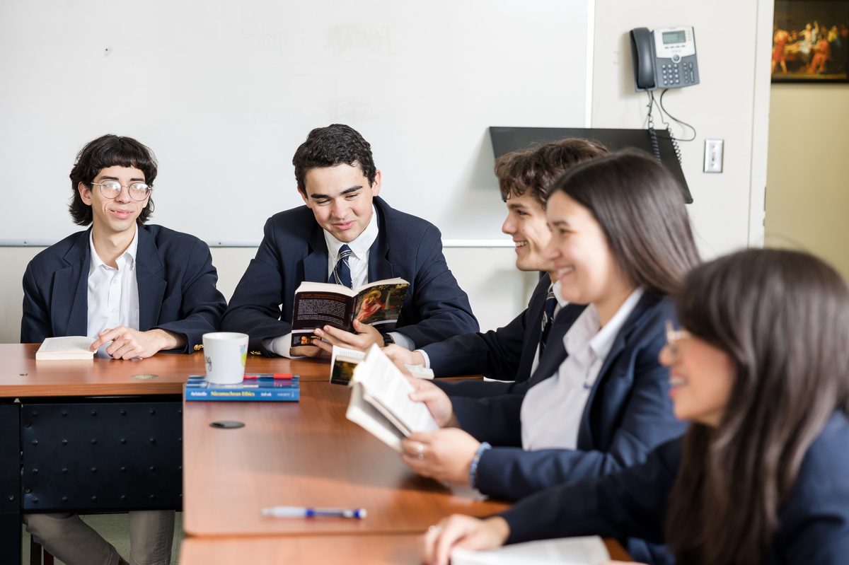 Great Hearts upper-school students discussing a book around a seminar table